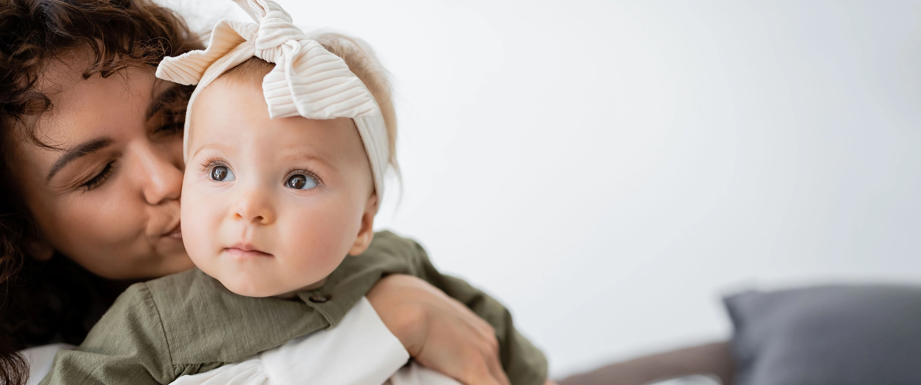 r71-curly-mother-hugging-and-kissing-cheek-of-baby-gir-2024-11-09-15-02-22-utc-17589842036488.jpg