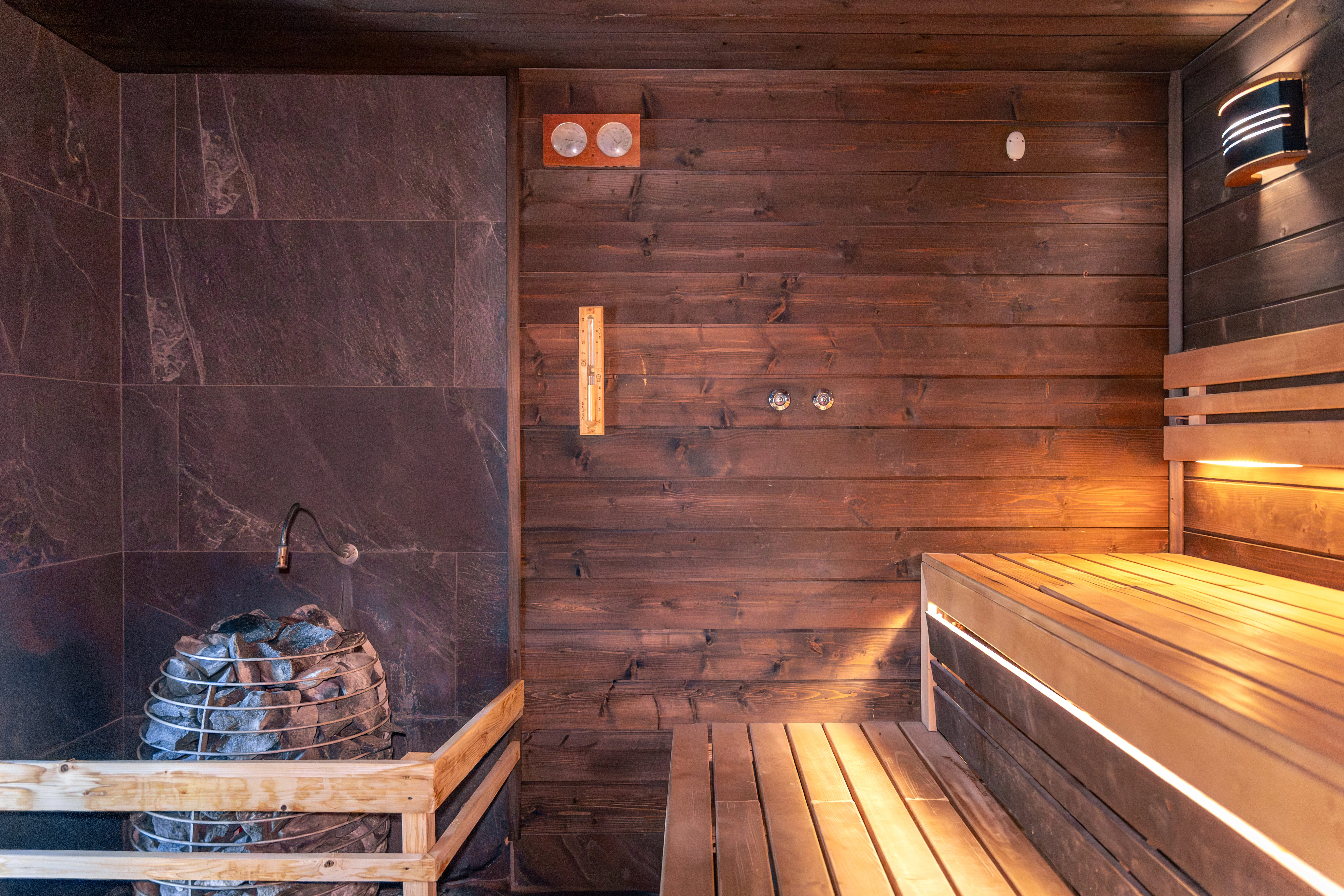 210-sauna-with-stones-thermometer-warm-benches-light-nordic-wellness-1-17651989678306.jpg