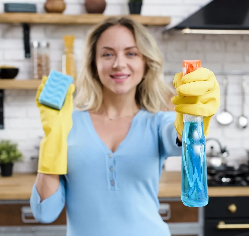 026100094744-smiling-woman-wearing-rubber-gloves-holding-detergent-with-sponge.jpg