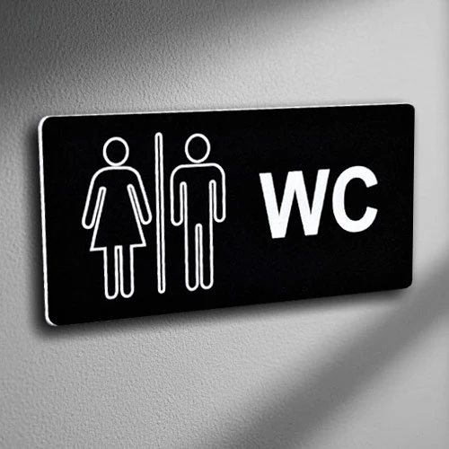 Табела за тоалетна от черен акрил с обозначения WC и контури на мъж и жена