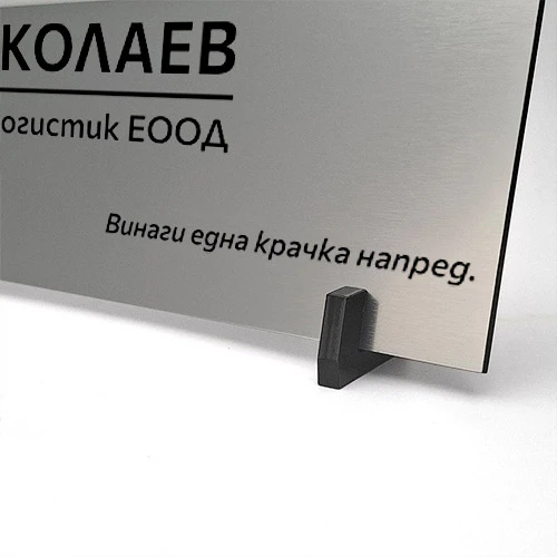 Гравирана фирмена табелка върху черна стойка от плексиглас