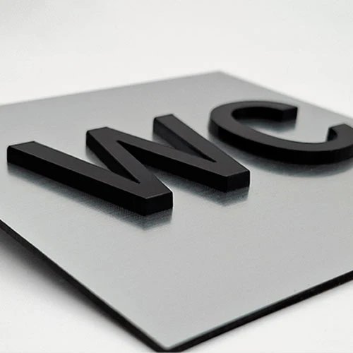 Табела тоалетна с обемен надпис WC от сребриста метализирана акрилна плоскост и надпис WC от черен плексиглас