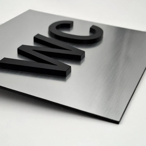 Табела тоалетна с обемен надпис WC от сребриста метализирана акрилна плоскост и надпис WC от черен плексиглас