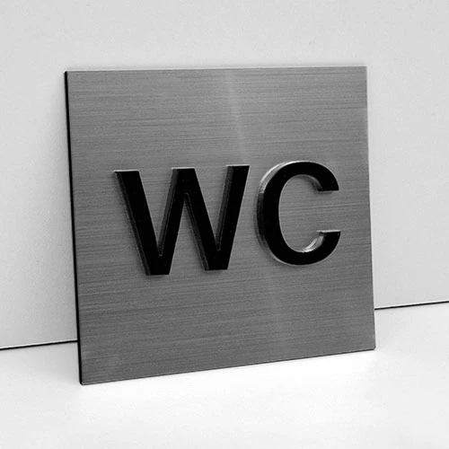 Табела тоалетна с обемен надпис WC от сребриста метализирана акрилна плоскост и надпис WC от черен плексиглас