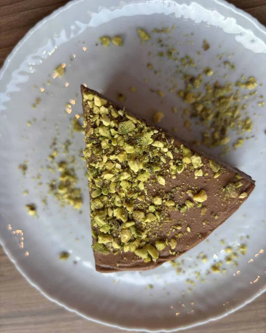 Апетитно парче кето торта Гараш без захар и брашно, с богати орехови блатове и черен шоколад, сервирано в десертна чиния