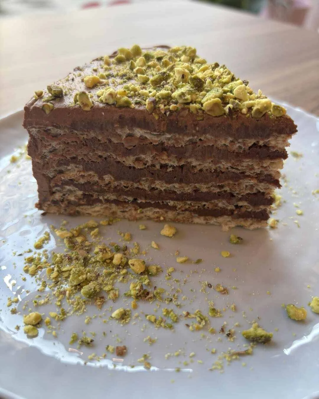 Близък план на разрез на нисковъглехидратна торта Гараш, показващ сочните слоеве от орехи и плътен кето шоколадов ганаш