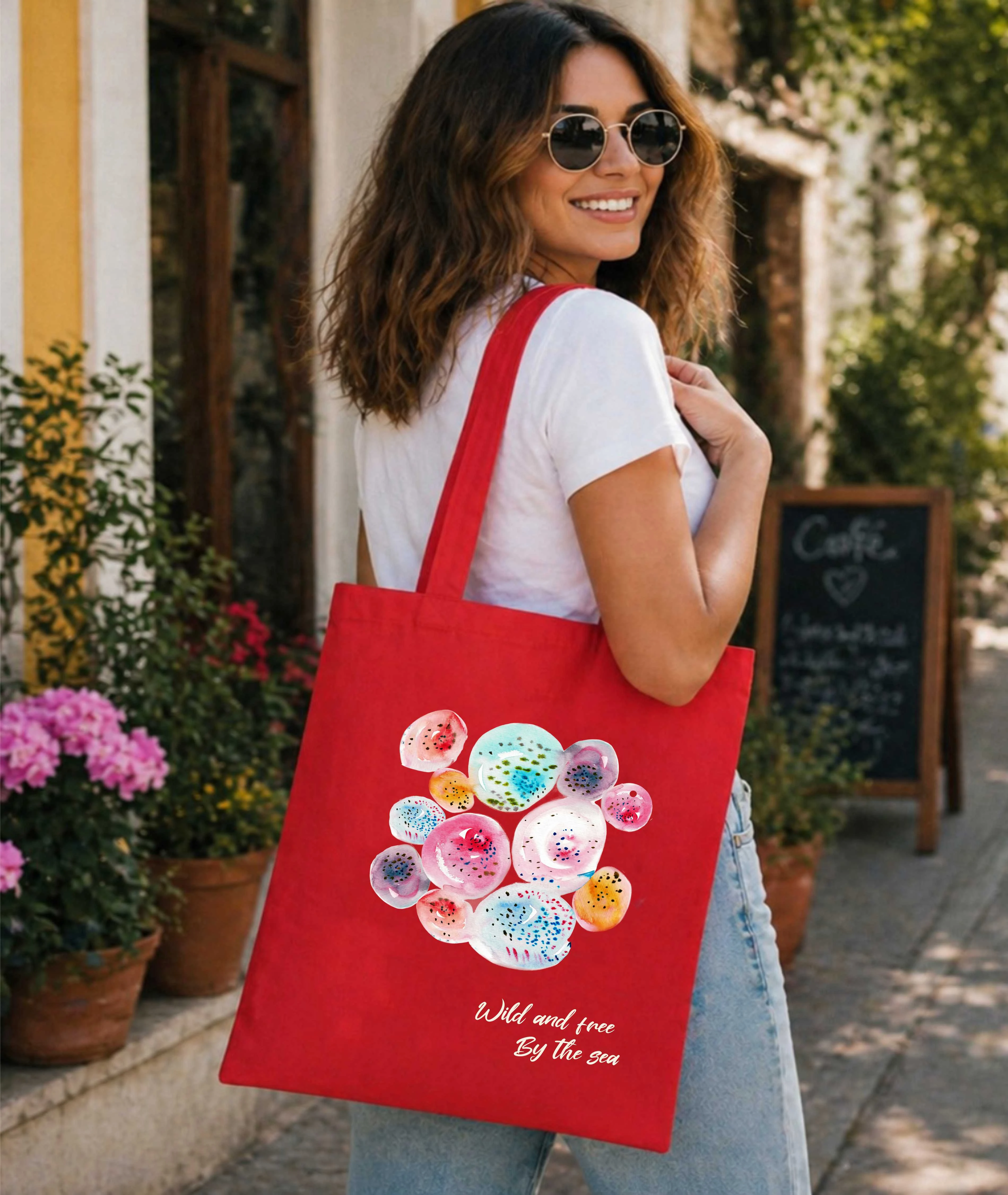 A woman carrying red tote bag with bubble art print and small text behind the print.