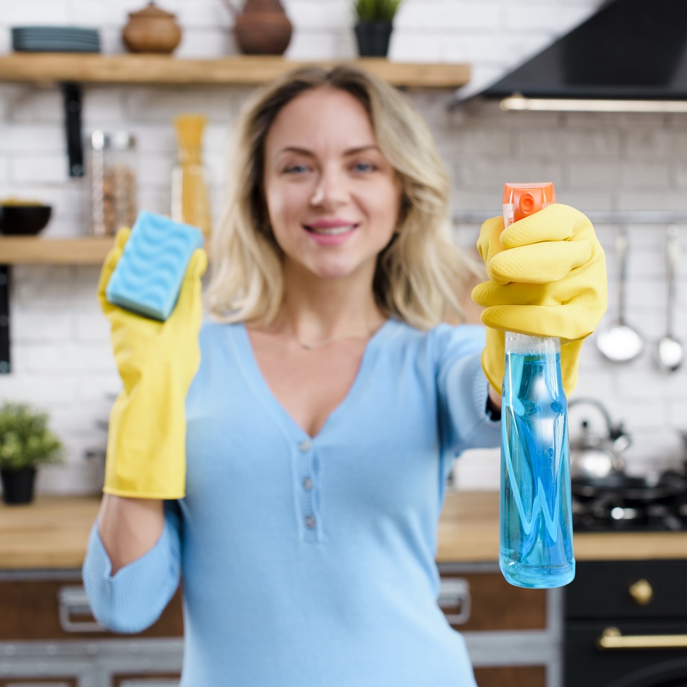 44-smiling-woman-wearing-rubber-gloves-holding-detergent-with-sponge.jpg