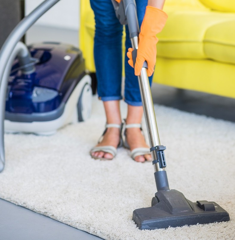 838678980551-close-up-woman-s-hand-cleaning-carpet-with-vacuum-cleaner.jpg