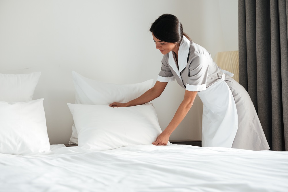 54-young-hotel-maid-setting-up-pillow-bed.jpg