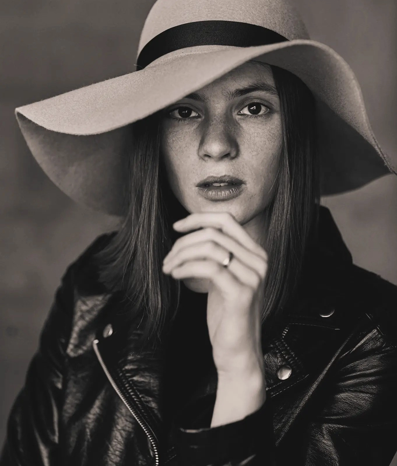 Черно-бял портрет на жена с шапка – символ на силата и креативността на маркетингова агенция Споделям