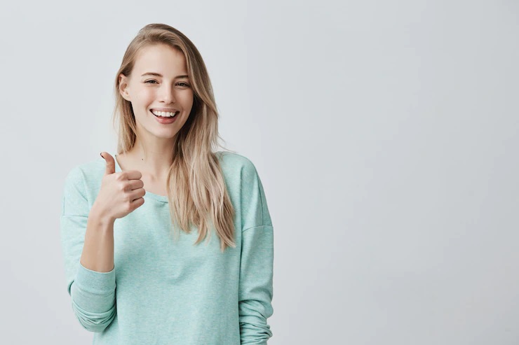 1129-happy-young-caucasian-female-wearing-blue-long-sleeved-shirt-making-thumb-up-sig.jpg