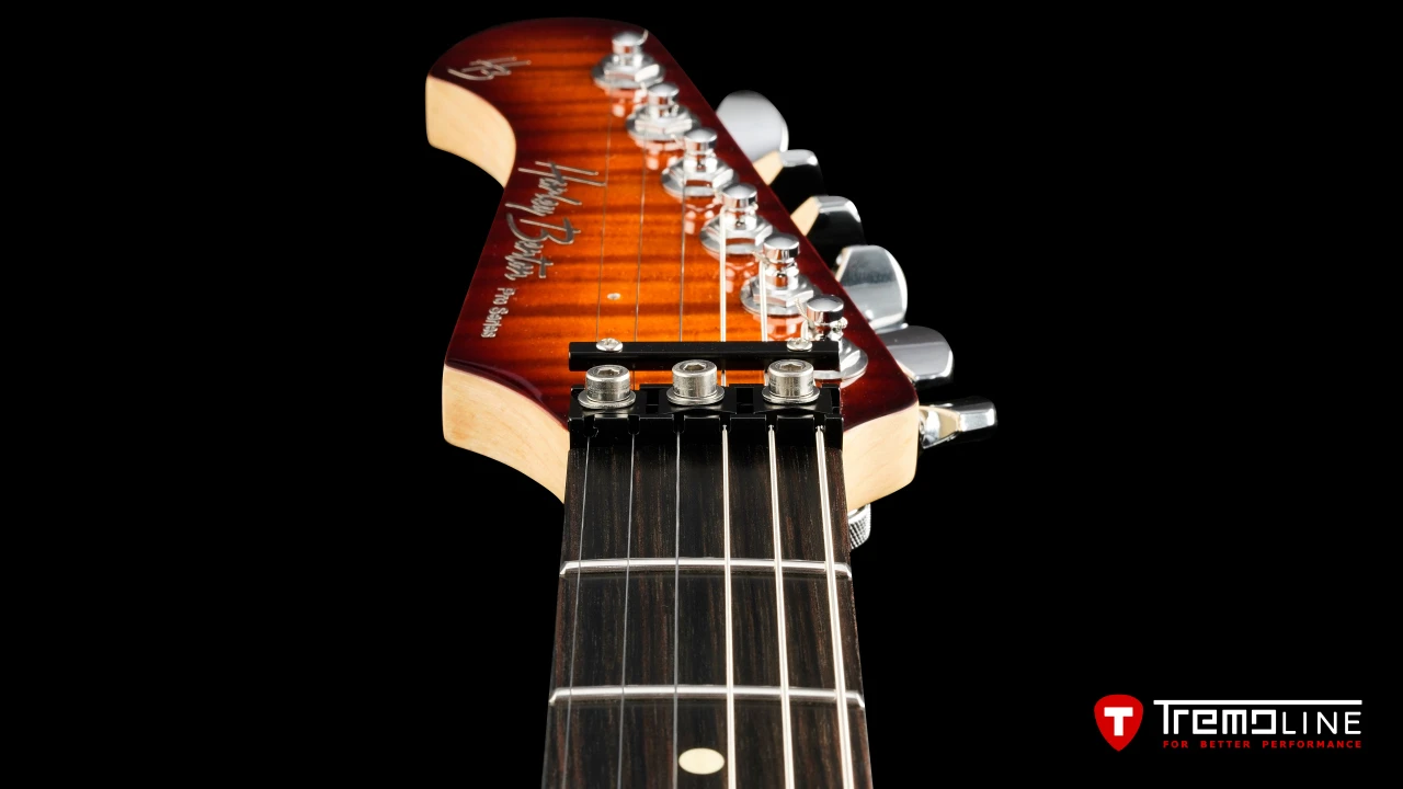 <img src=”Tremoline-guitar-double-locking-tremolo-Harley-Benton-Fusion-LH-1280x720-I3C.jpg” width="1280" height="720" alt=”Tremoline LN6A locking nut on Harley Benton Fusion III LH guitar” />